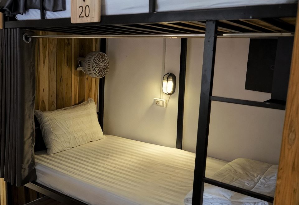 A numbered wooden bunk with its own lamp, curtain and shelf