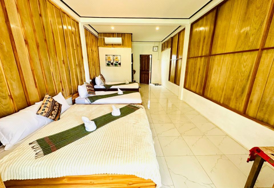 A row of made-up mattresses along a wood-panelled room