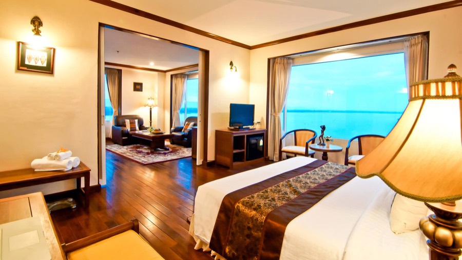 A suite with a double bed and an adjoining sitting room, its window looking over the river