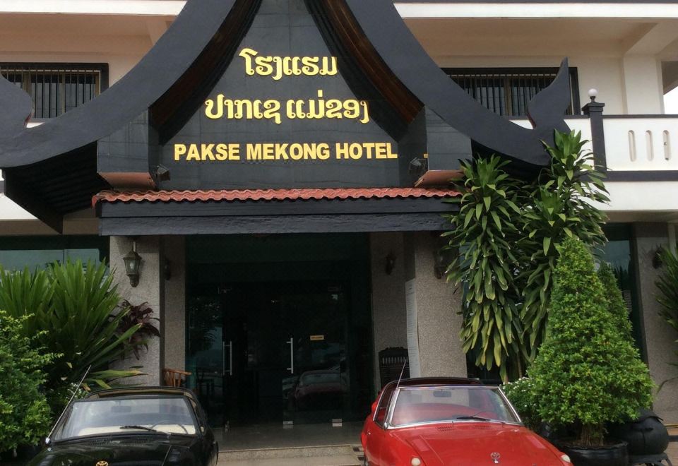 The hotel entrance under a tiled portico, its name in Lao and English above