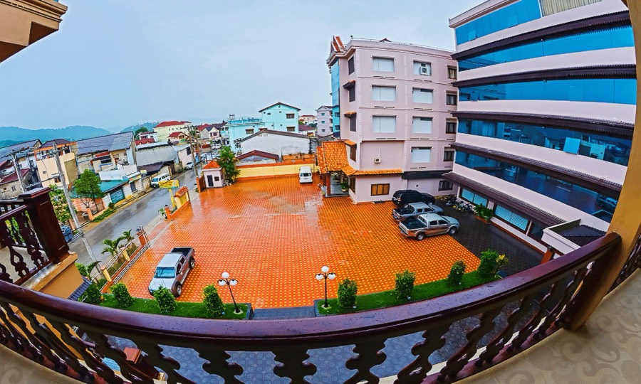 The tiled forecourt seen from an upper balcony, with the guest-room block to one side