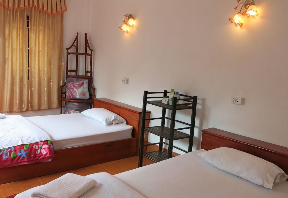 A twin room with two beds, a bunk to one side and patterned throws