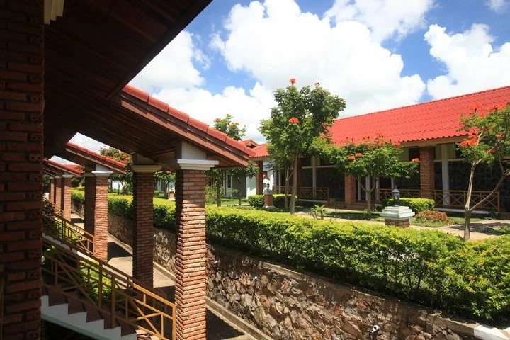 Single-storey guest-room wings with red tiled roofs around a hedge garden