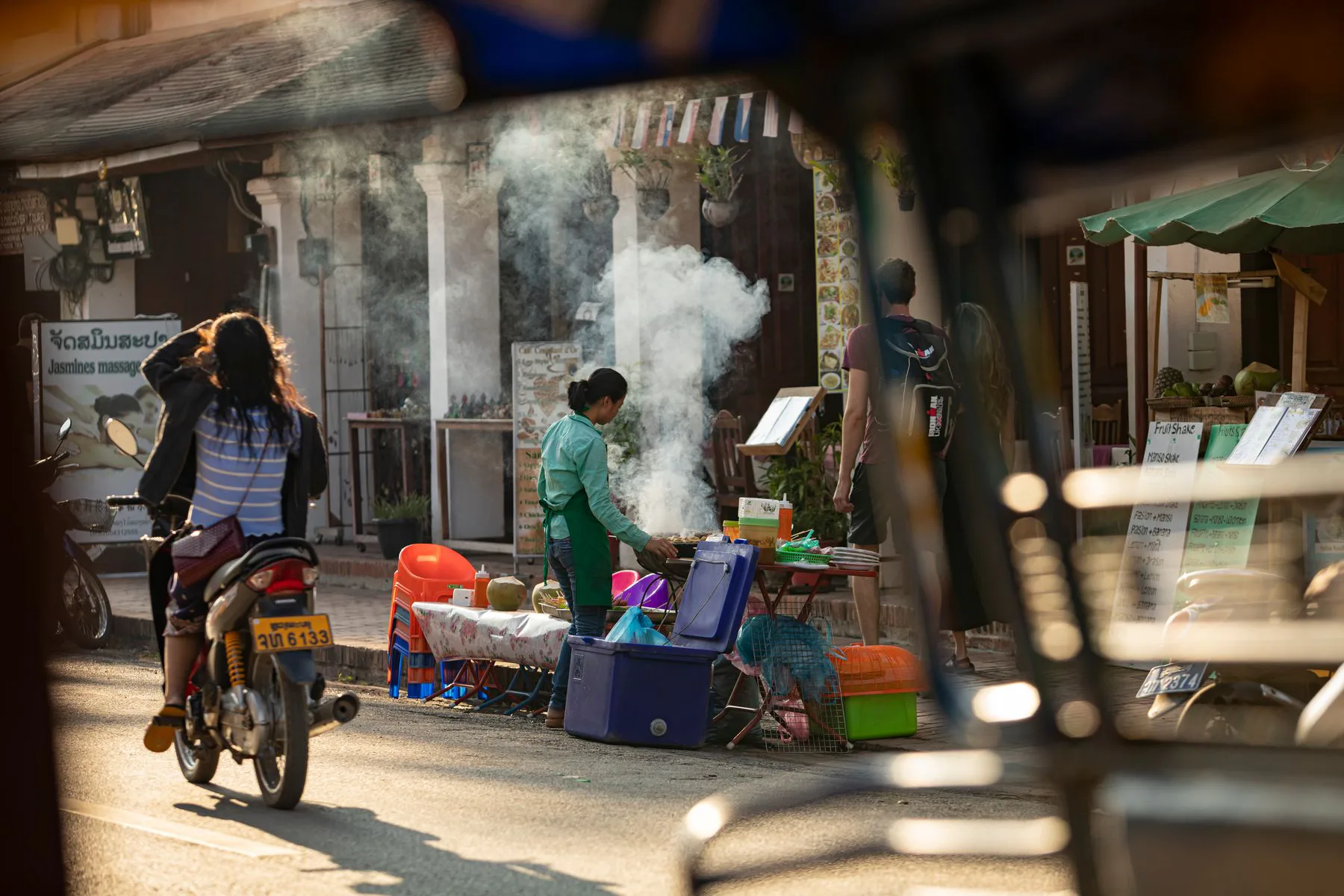 A busy street food market with steaming stalls in Laos